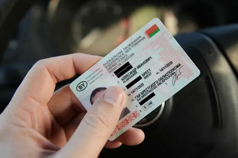 Руки на руле и брелок на ключе в салоне автомобиля перед экзаменом