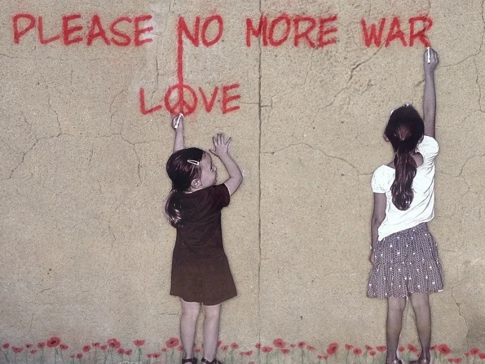 Уличное граффити с двумя девочками и надписью «Please no more war Love
