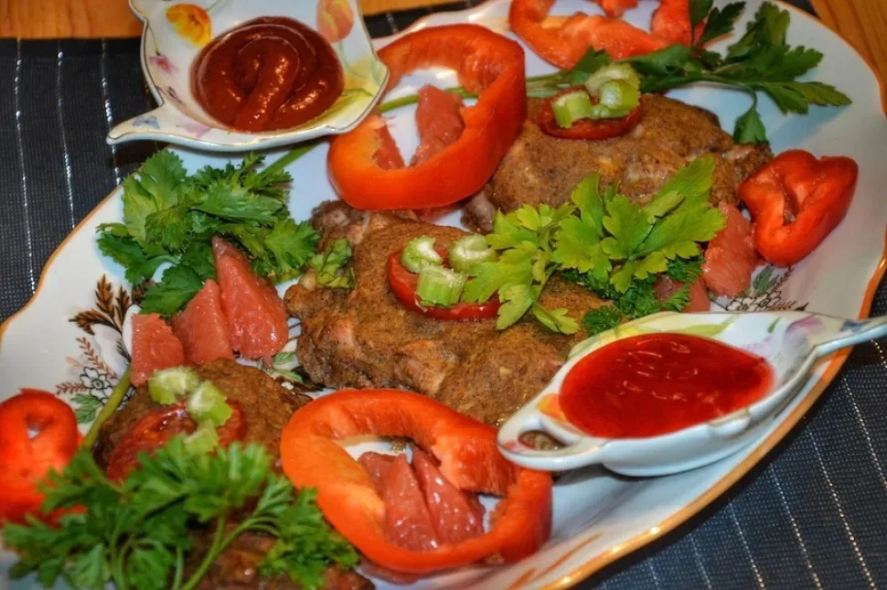 Кусочек запечённой курицы в окружении петрушки и грейпфрута