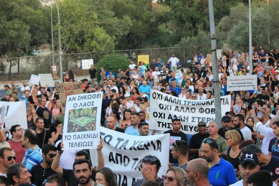 Плотная толпа демонстрантов с разными плакатами против ограничений и вакцинации