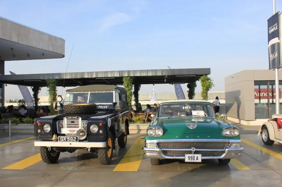 Ряд ретро‑автомобилей на большой открытой парковке возле The Mall of Cyprus