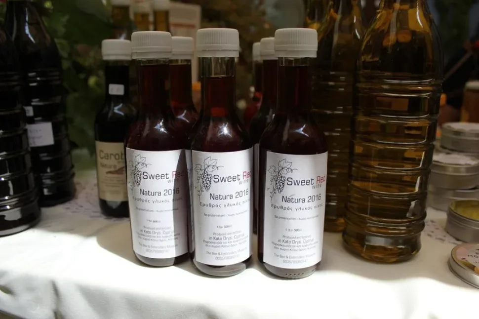 Рядами выставлены банки мёда на столе с рисунком лефкаритики