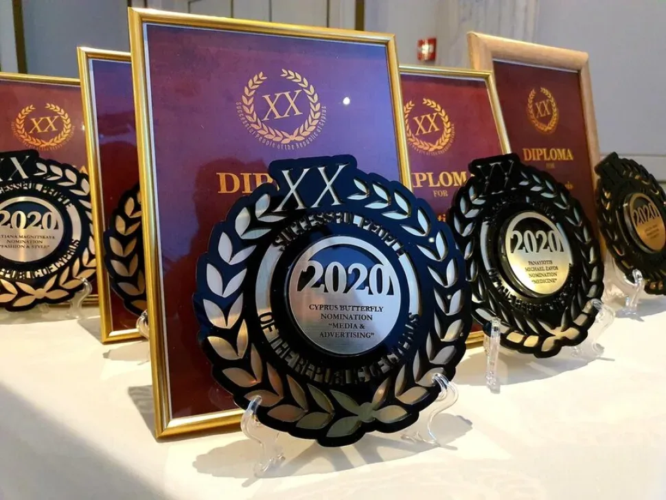 Столы с наградами и дипломами премии XX с надписью 2020
