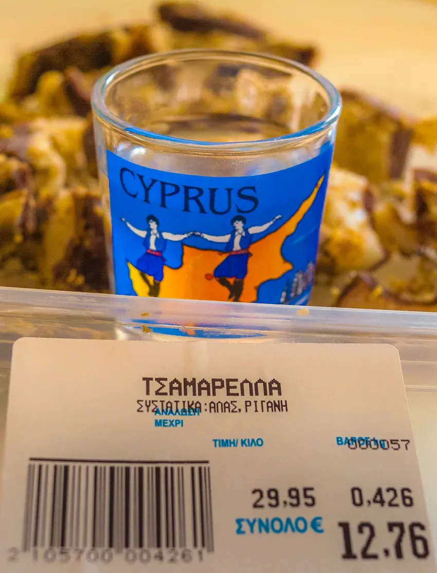 Ближний план стаканчика с надписью Cyprus среди кусочков цамареллы