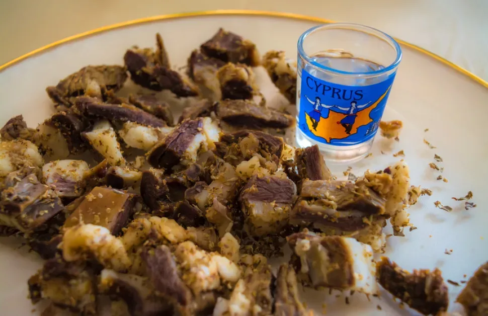 Нарезка кипрской цамареллы на тарелке с кусочками мяса и орегано