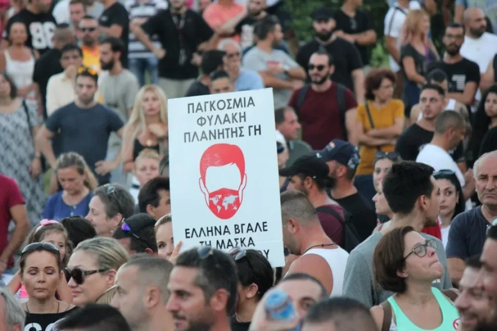 Толпа людей держит плакаты, среди них виден двуглавый орёл на жёлтом фоне
