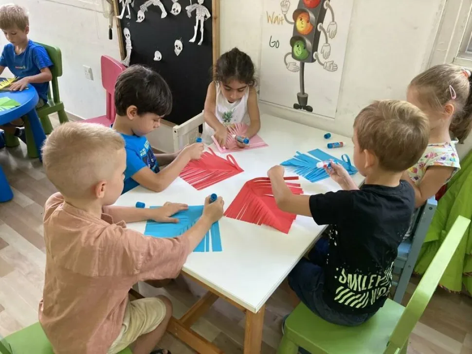 Поделки в виде ракет, разложенные на столе в детской группе Поделки в виде ракет, разложенные на столе в детской группе