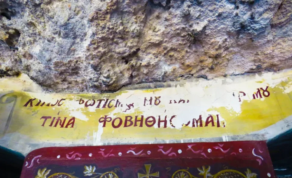 Фрагмент надписи на греческом языке над аркой внутри пещерного храма Фрагмент надписи на греческом языке над аркой внутри пещерного храма