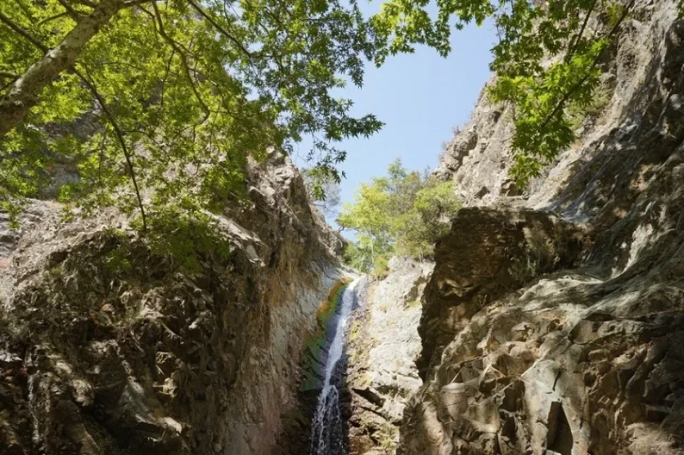 Каменная лесная лестница и скамейки на подходе к подножию водопада