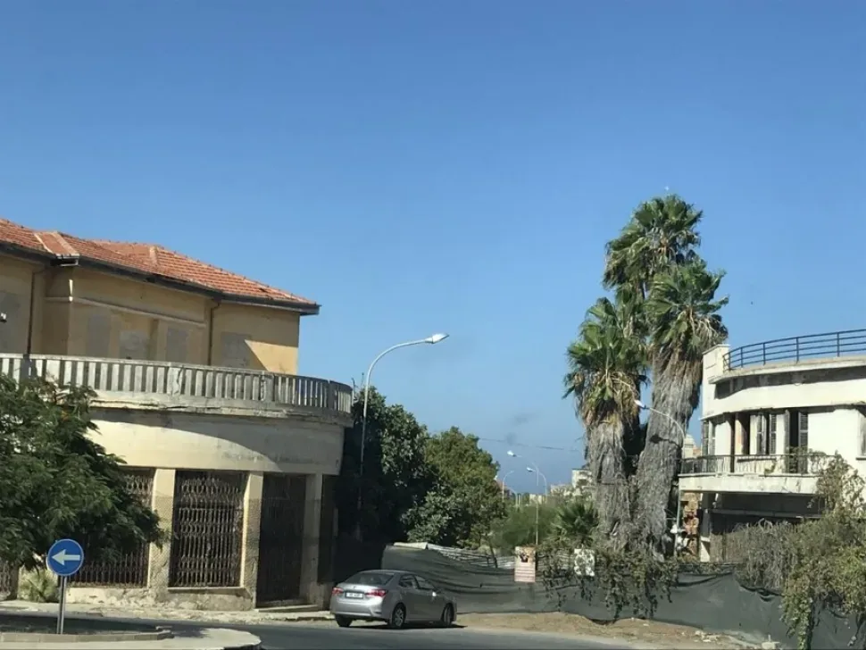 Загороженные старые здания и пальмы на тихой улице Фамагусты