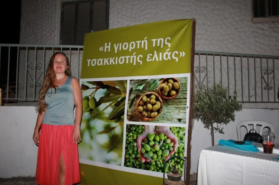 Два человека в национальных одеждах позируют у баннера фестиваля Два человека в национальных одеждах позируют у баннера фестиваля