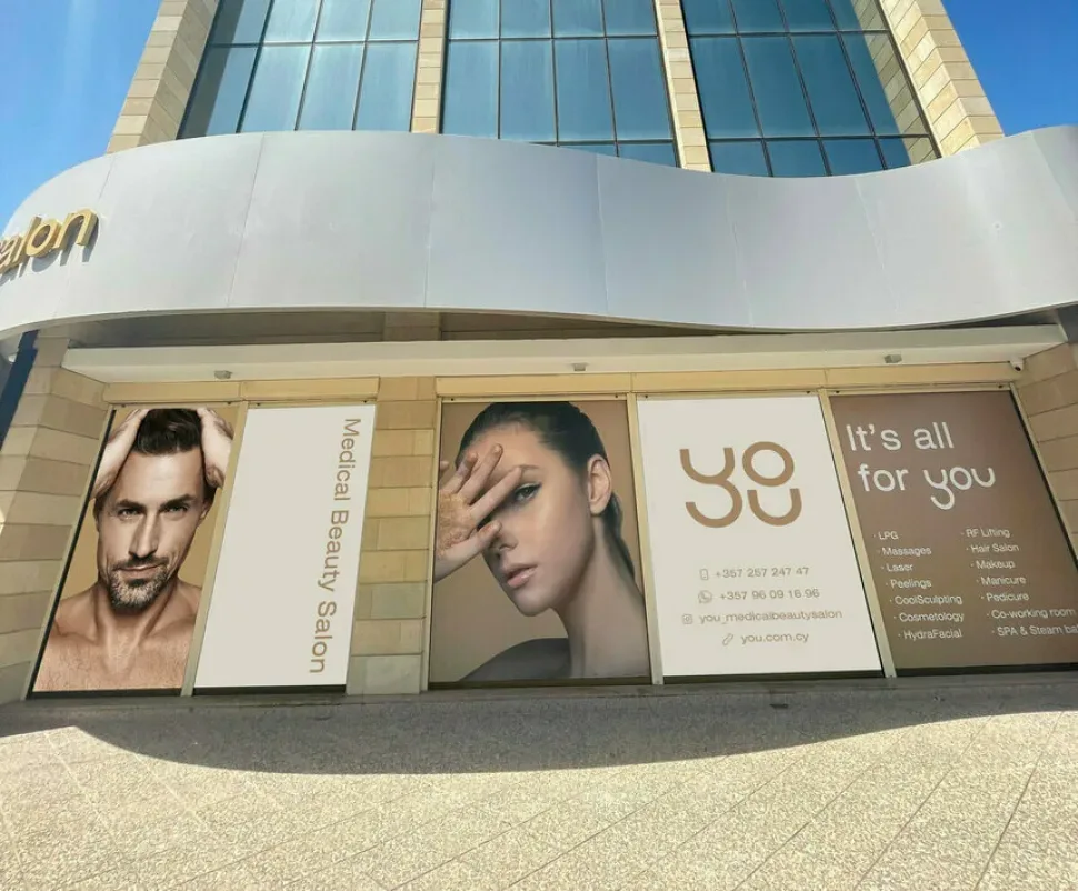 Фасад и витрина салона YOU Medical Beauty Salon с крупной рекламой и изображениями моделей