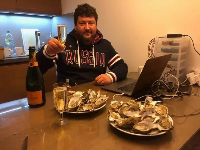 Интервьюируемый за столом с устрицами и бокалом шампанского Интервьюируемый за столом с устрицами и бокалом шампанского