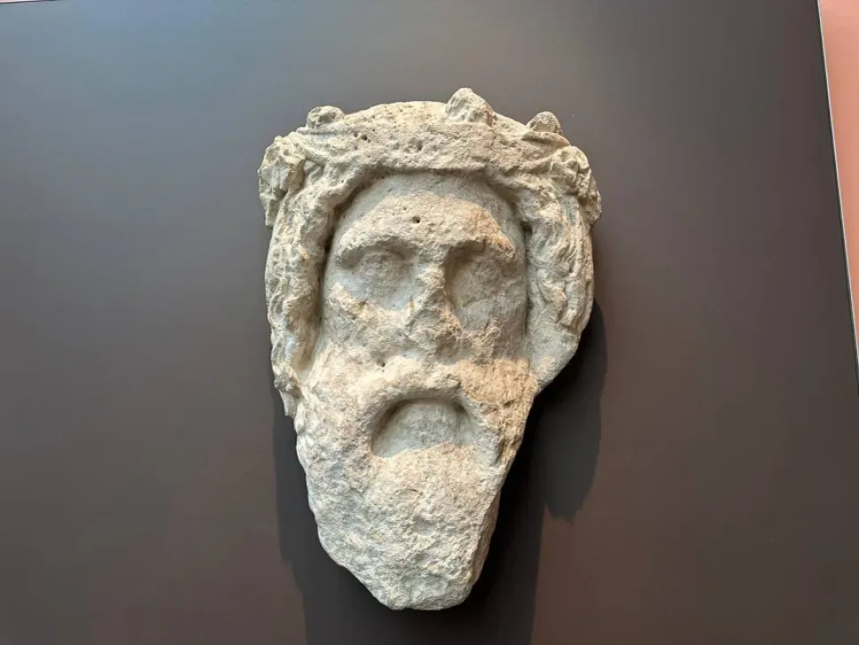 Каменная голова Диониса, найденная в стене караван-сарая у Соли, на тёмном фоне