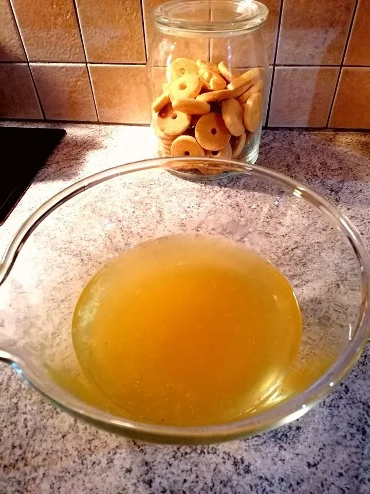 Процеженный куриный бульон в стеклянной миске на столе