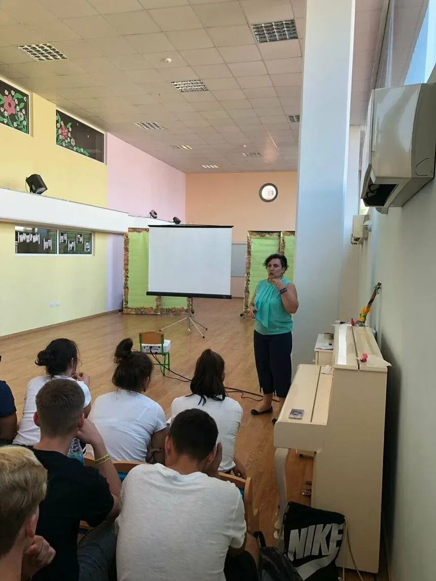 Преподаватель в классе проводит презентацию для группы школьников