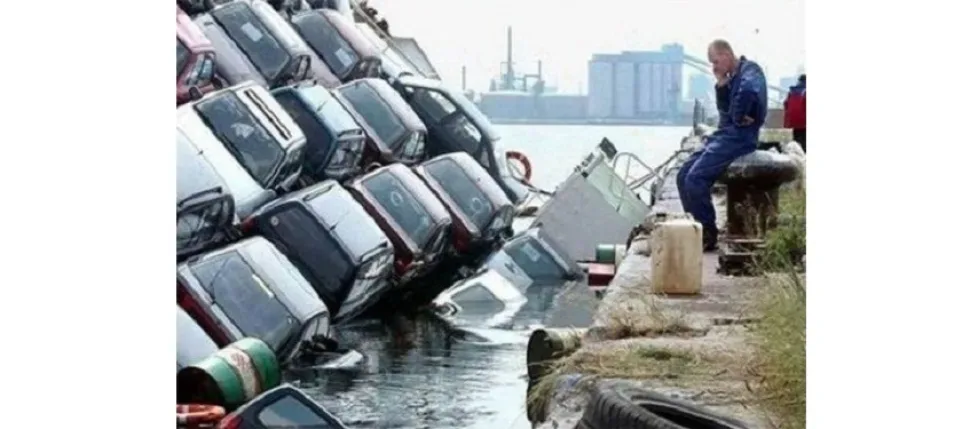 Ряд частично затопленных автомобилей у кромки воды на причале Ряд частично затопленных автомобилей у кромки воды на причале