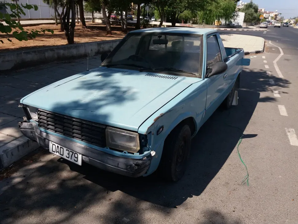 Красный Hyundai Pony с ушибленным передним бампером ожидает ремонта