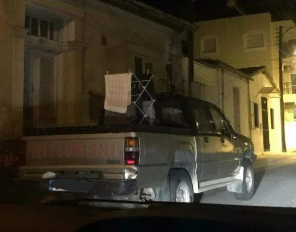 Автомобиль припаркован на склоне, поддерживаемый корягой под дверью