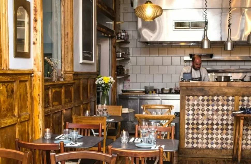 Интерьер Peckham Bazaar с открытой кухней, печью и деревянной мебелью