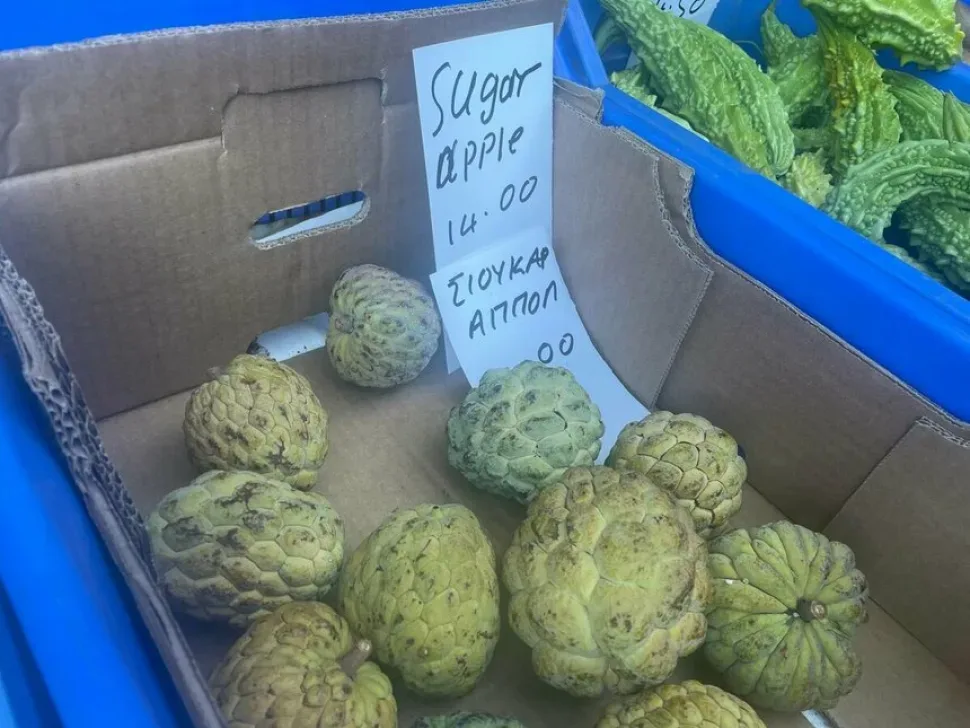 Коробка с плодами анноны и бумажной табличкой «Sugar apple» на лотке
