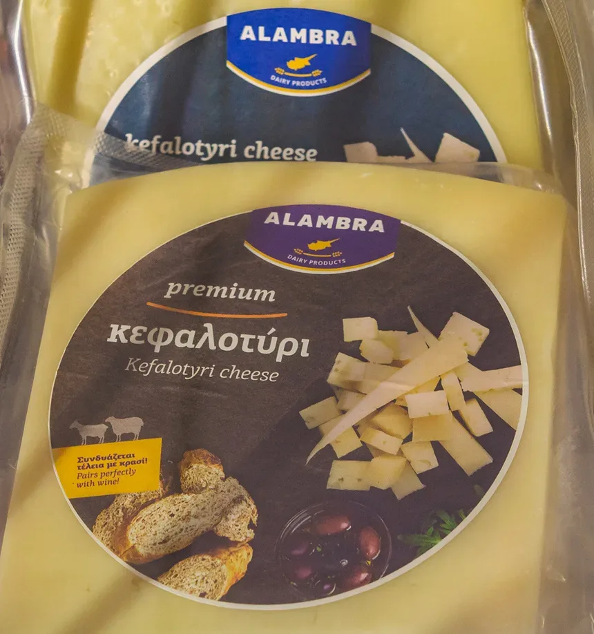 Кусок Кефалотири с круглой этикеткой premium и изображением хлеба и оливок