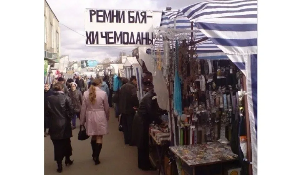 Уличная торговая ярмарка с палатками и вывесью про ремни и чемоданы