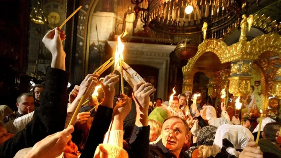 Верующие подносят и зажигают свечи в храме Гроба Господнего при Благодатном огне Верующие подносят и зажигают свечи в храме Гроба Господнего при Благодатном огне
