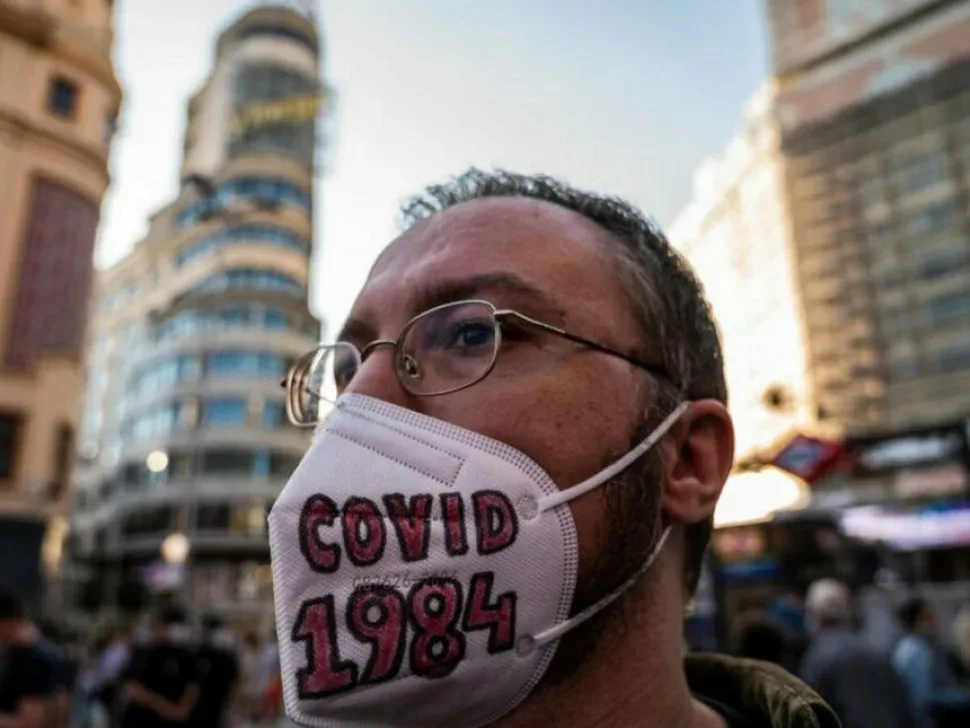 Мужчина в маске с надписью COVID 1984 на антивакцинаторском митинге Мужчина в маске с надписью COVID 1984 на антивакцинаторском митинге