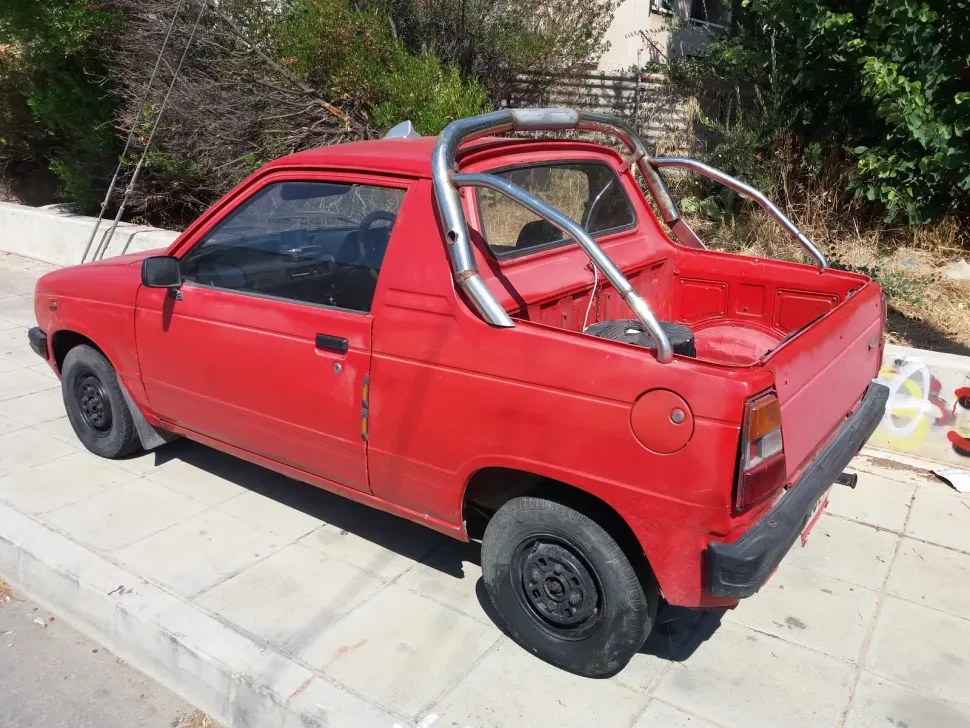 Потрёпанный компактный пикап Suzuki Mighty Boy на обочине