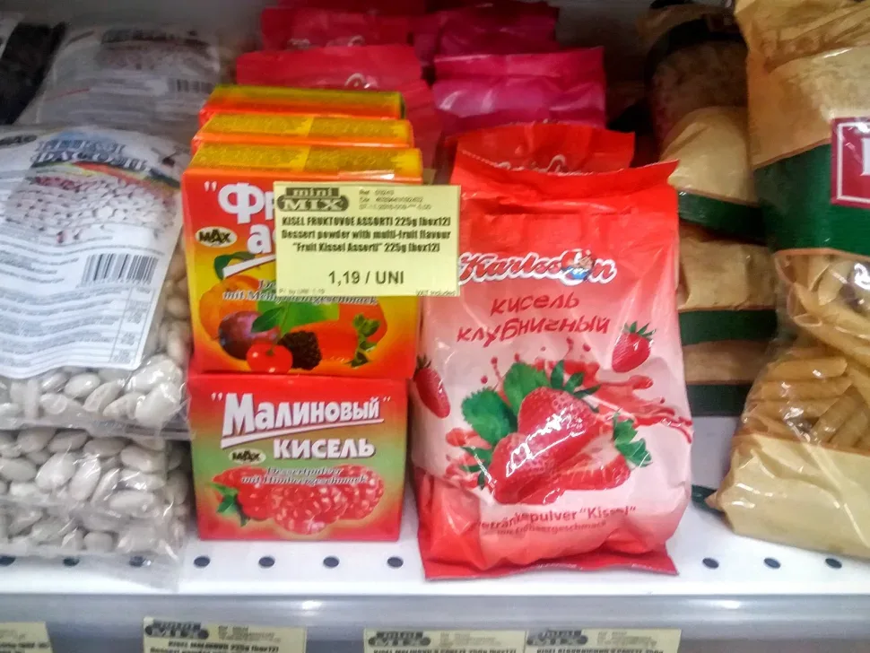 Полка с разными баночными шпротами и консервами в золотых и чёрных банках Полка с разными баночными шпротами и консервами в золотых и чёрных банках