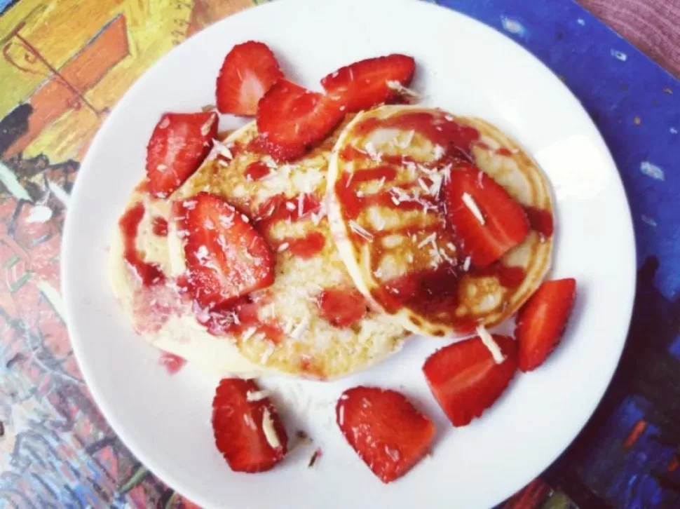 Пушистые панкейки с ломтиками клубники и клубничным сиропом