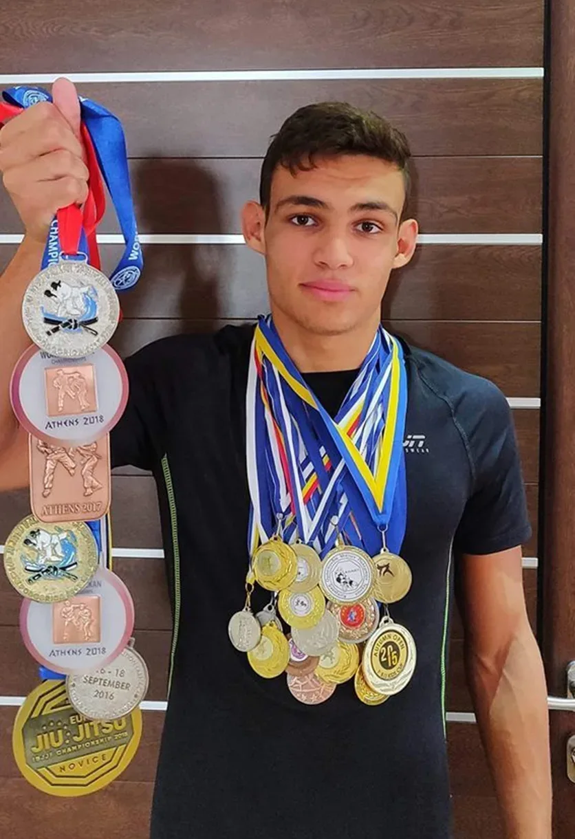 Подросток‑чемпион позирует с наградами и многочисленными медалями на шее