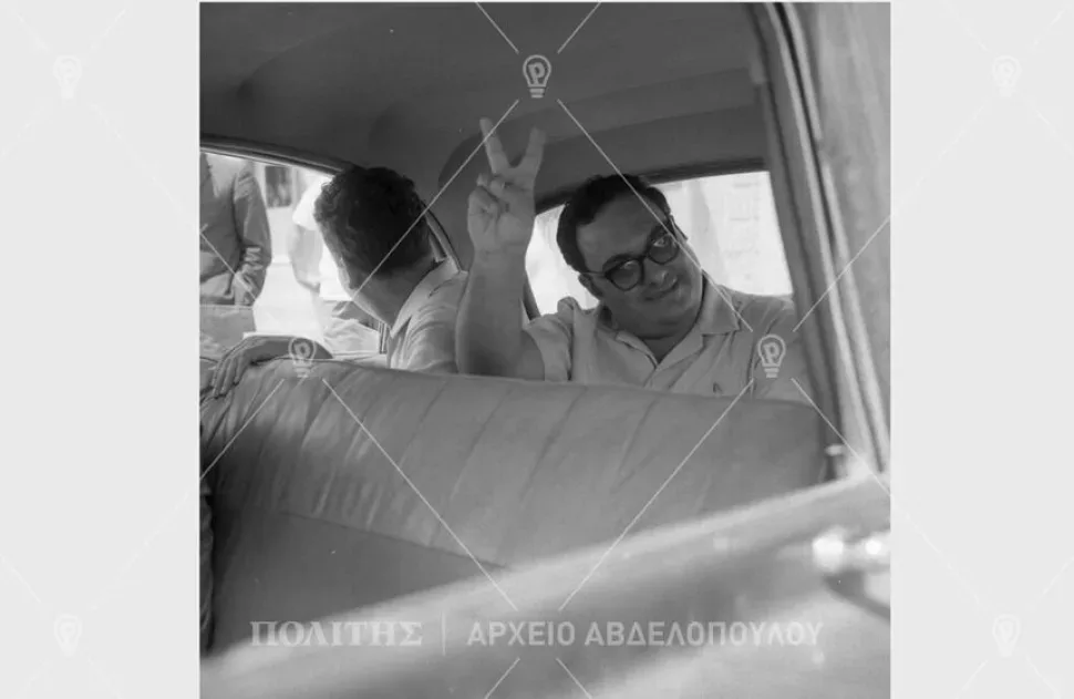 Мужчина в салоне автомобиля показывает победный жест рукой V Мужчина в салоне автомобиля показывает победный жест рукой V