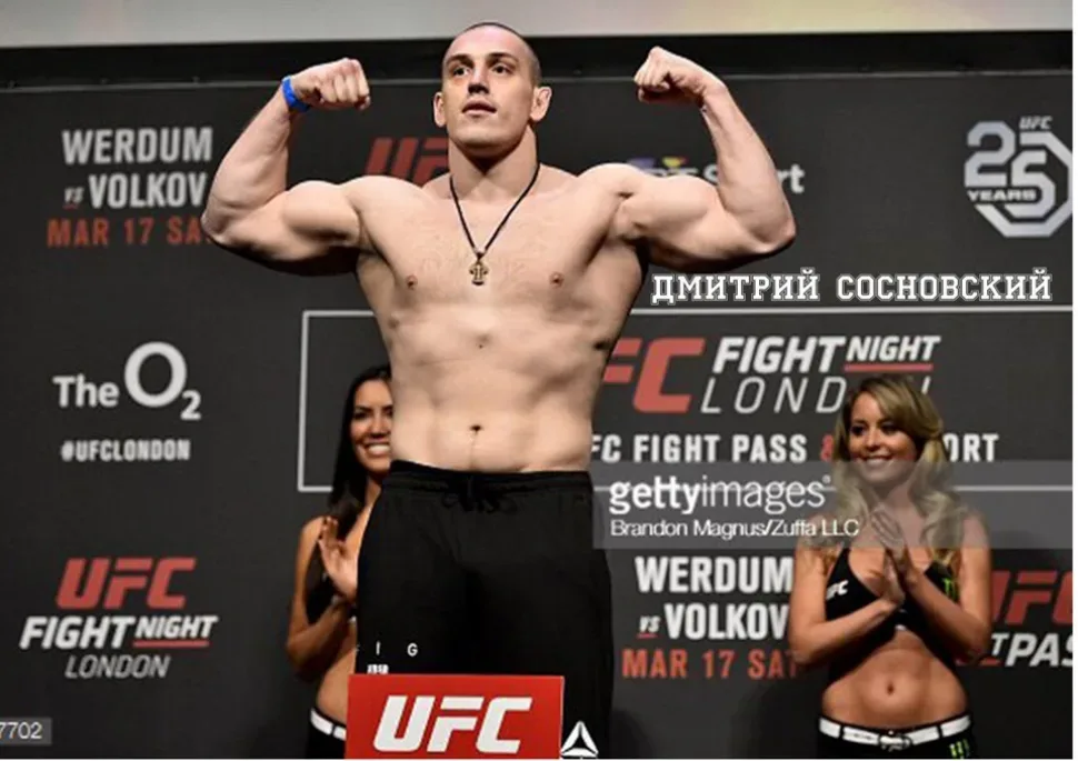 Боец на взвешивании на сцене UFC позирует с поднятыми руками Боец на взвешивании на сцене UFC позирует с поднятыми руками