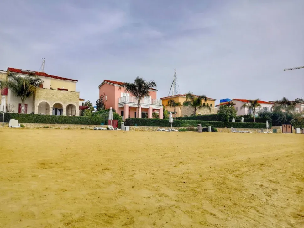Пустой жёлтый пляж перед прибрежными домами в Limassol Marina Пустой жёлтый пляж перед прибрежными домами в Limassol Marina