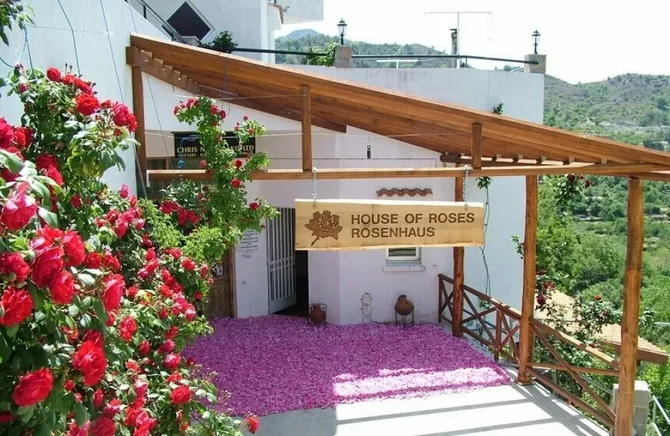 Вход в розовую фабрику Агроса House of Roses с ковром лепестков и вывеской