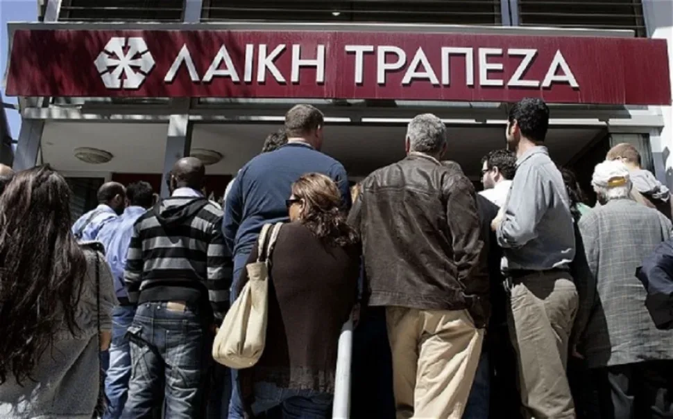 Очередь людей у входа в отделение Laiki Bank с вывеской банка Очередь людей у входа в отделение Laiki Bank с вывеской банка