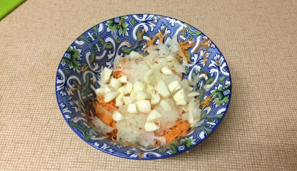 Миска с натёртой морковью, рубленым луком и дольками чеснока