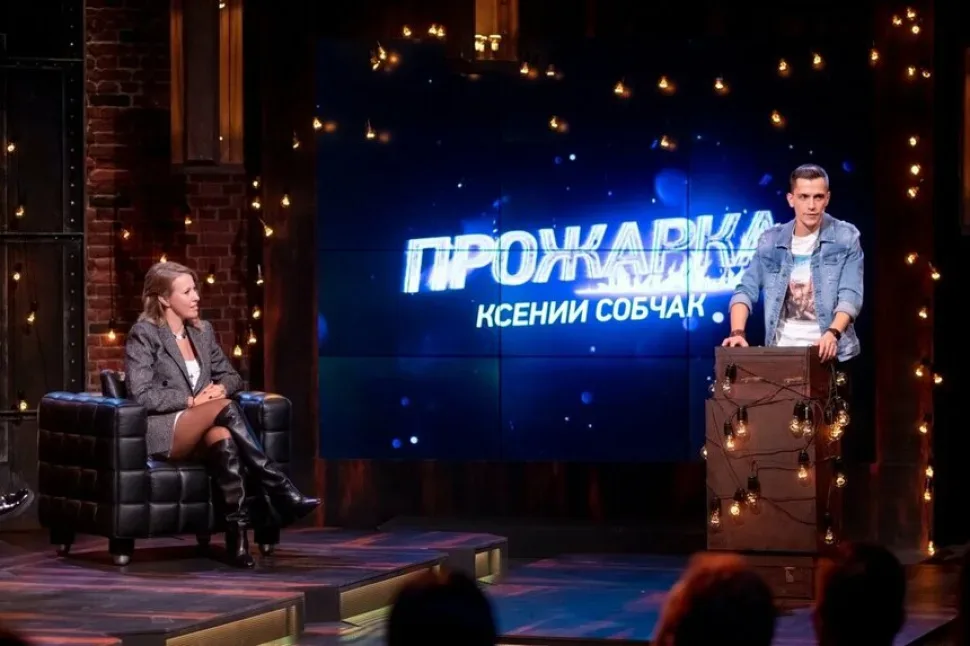 Кадр из шоу «Прожарка» с ведущей и выступающим комиком на сцене