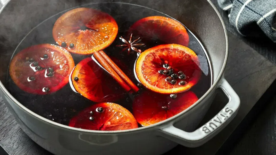 Кастрюля с горячим пряным вином, апельсиновыми дольками и специями Кастрюля с горячим пряным вином, апельсиновыми дольками и специями