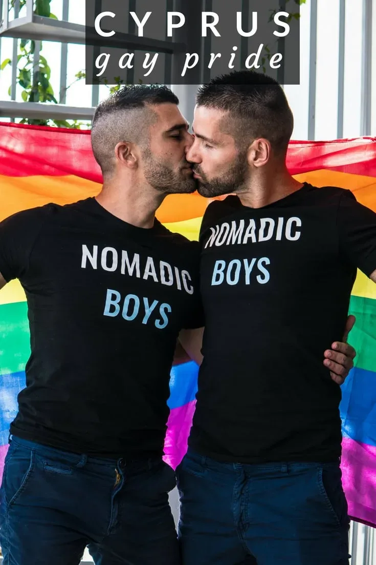 Пара мужчин целуется на фоне радужного флага и слогана Pride