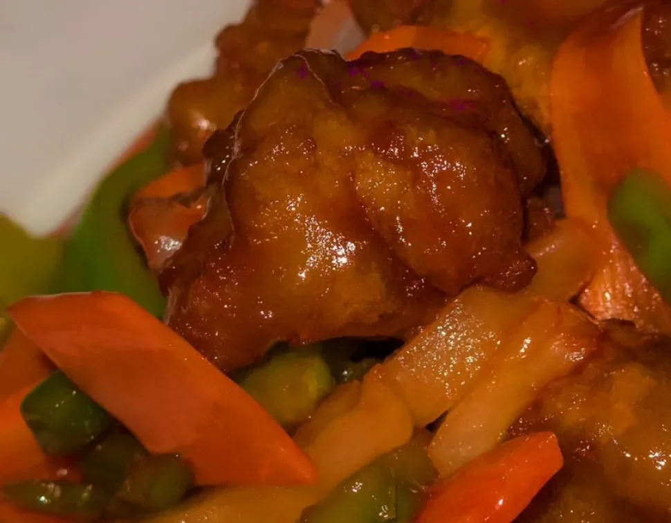 Жареные кусочки курицы в кляре с овощами и густым кисло‑сладким соусом