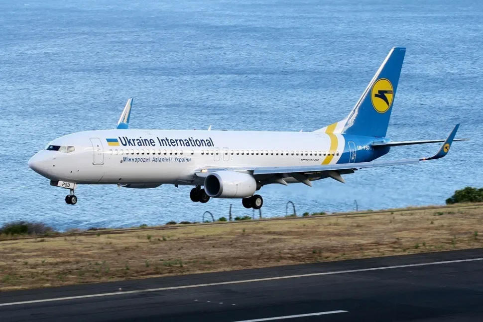 Самолёт Ukraine International Airlines у взлётно‑посадочной полосы, символ депортации в Украину