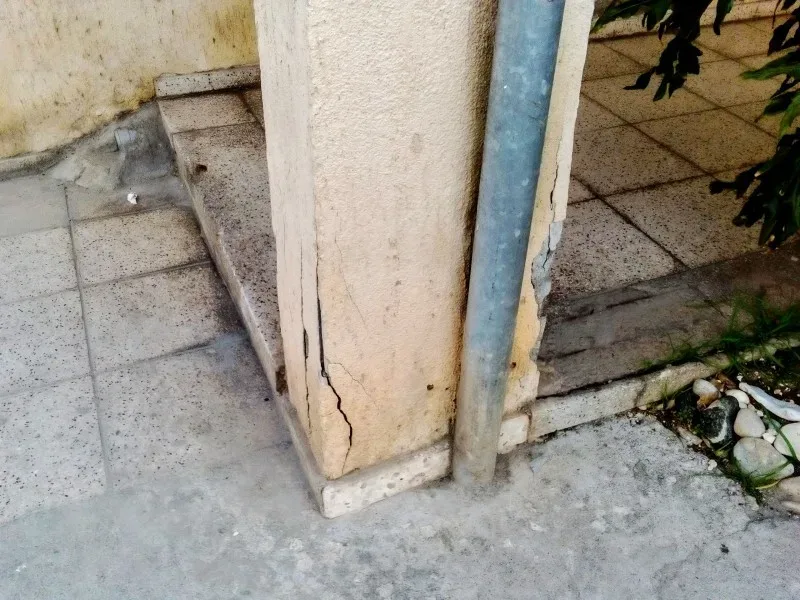 Трещина у основания колонны и водосточная труба в подъезде дома Трещина у основания колонны и водосточная труба в подъезде дома