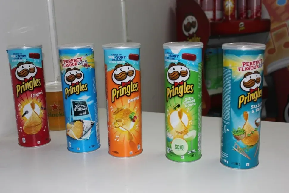 Девушка с лотком и банками Pringles раздаёт продукцию посетителям