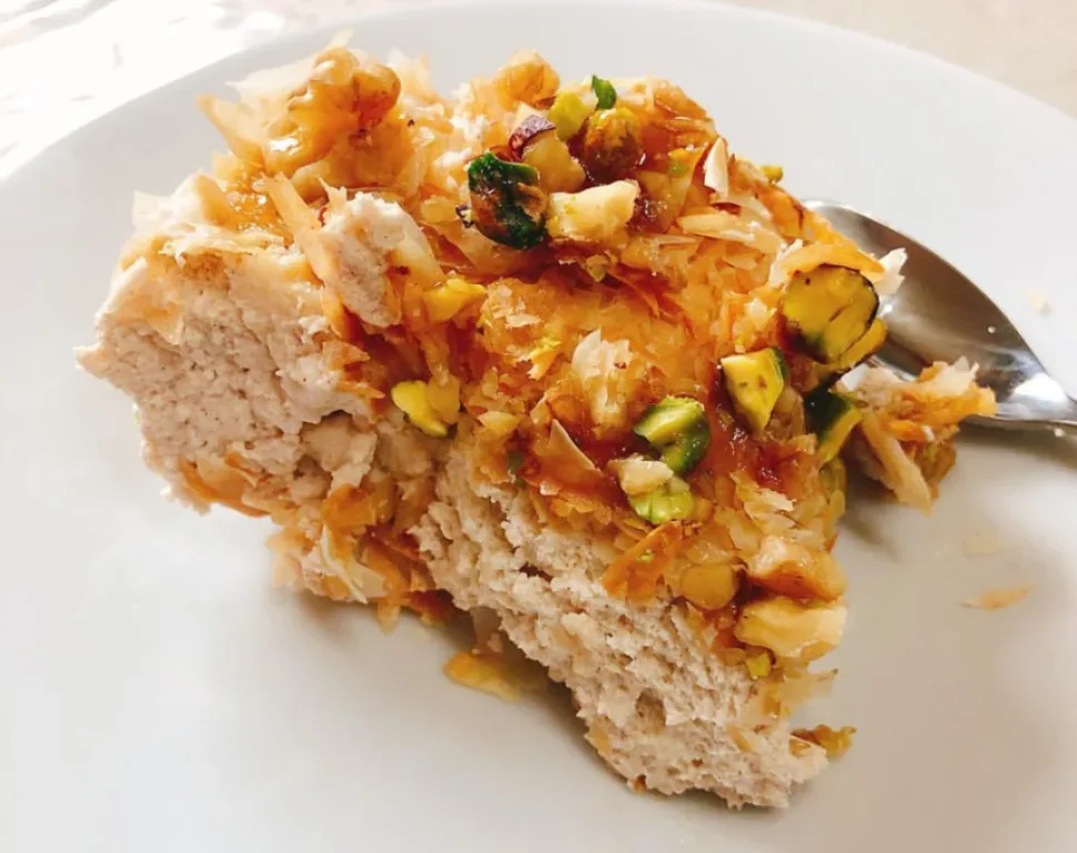Порция Анарокрема на тарелке с фисташками, медом и хрустящими кусочками теста