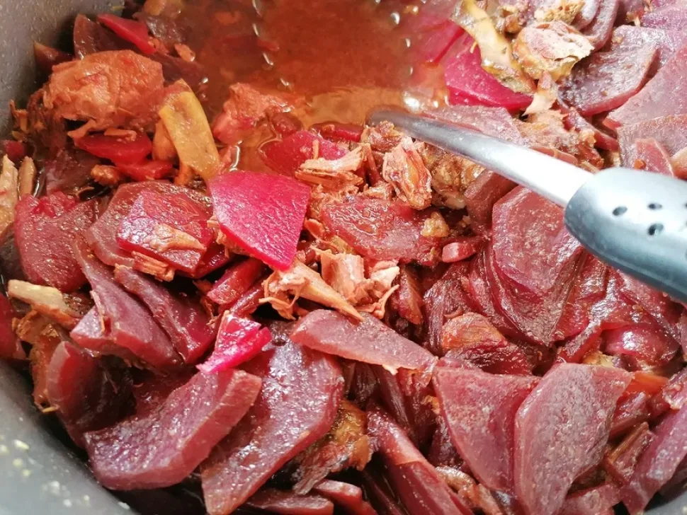 Кастрюля с кусками свинины и ломтиками свеклы перед тушением