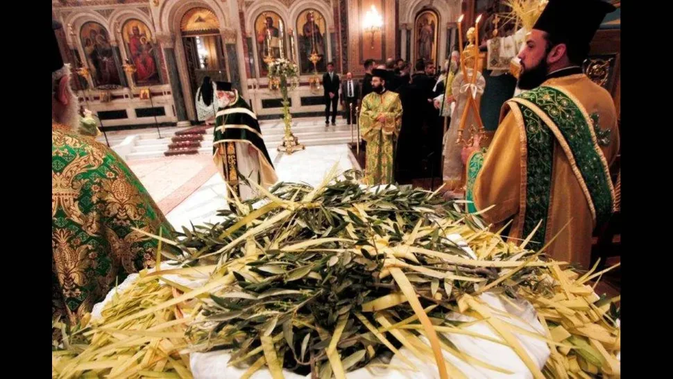 Православный священник во время праздничного богослужения с пальмовыми ветвями