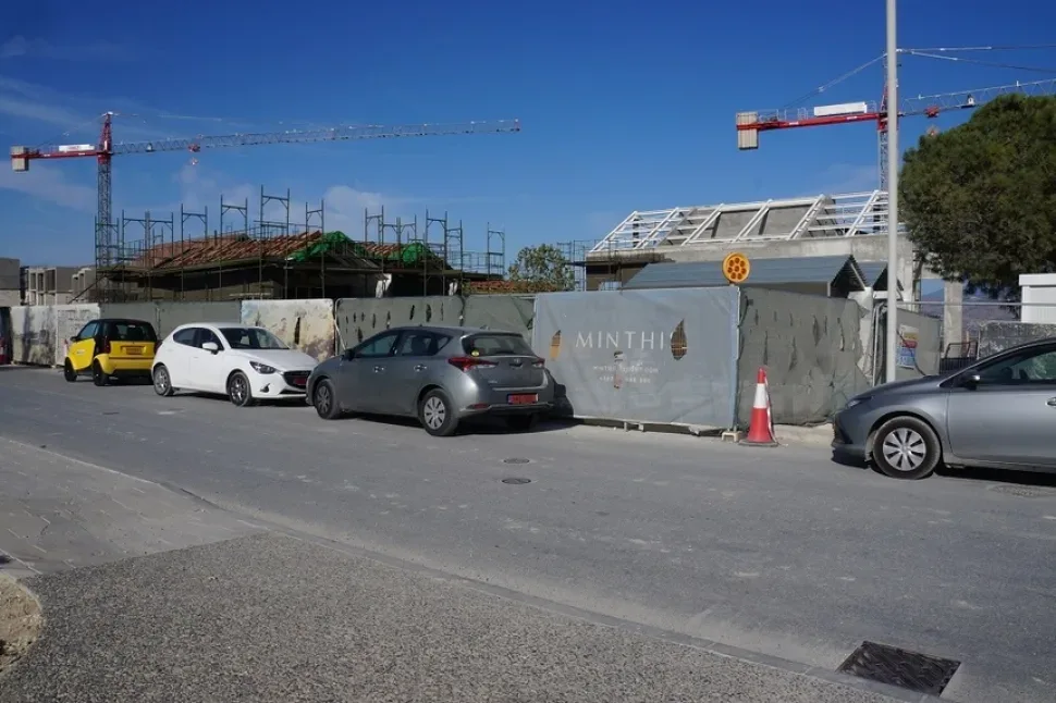 Фургоны и припаркованные автомобили у стройплощадки Minthis Hills
